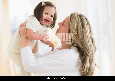 Madre ispanica giocando con nostra figlia nel soggiorno Foto Stock