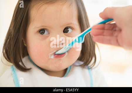 Madre ispanica toddler di alimentazione Foto Stock