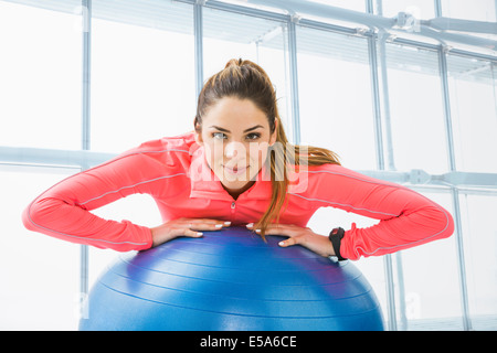 Razza mista donna con palla ginnica in palestra Foto Stock