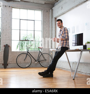 Architetto caucasica utilizzando il cellulare in ufficio Foto Stock