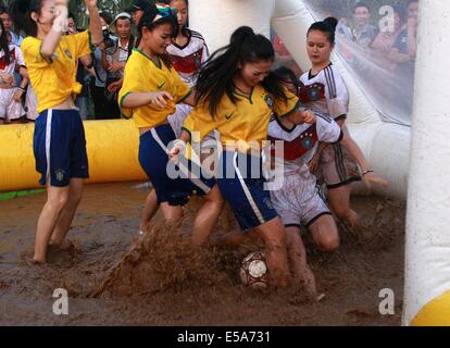 Due gruppi di ragazze che indossano la Germania national football team jersey e Brasile team nazionale jersey gioca il calcio di fango sulla luglio 13, 2014 a Xi'an, Shaanxi provincia della Cina.il calcio di fango è stato originato dalla Finlandia, ed è diventato sempre più popolare in Cina. Foto Stock