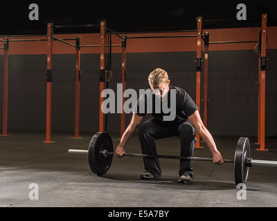 Uomo caucasico sollevamento pesi nella palestra Foto Stock