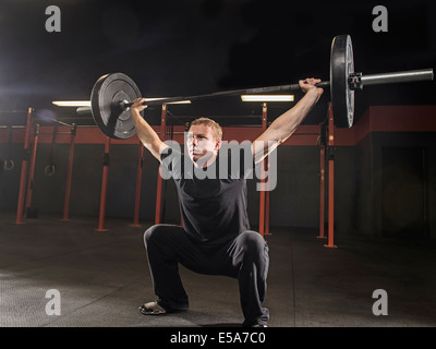 Uomo caucasico sollevamento pesi nella palestra Foto Stock