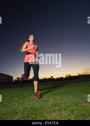 La donna caucasica jogging all'aperto presso sunrise Foto Stock