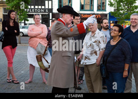 Il Ripon Hornblower George Pickles che ambienta l'orologio, suona l'antico corno alle 21:00 ogni sera, qui, spiegando cosa succede ai turisti. Ripon, Yorkshire Inghilterra Regno Unito 2014 2010s HOMER SYKES Foto Stock