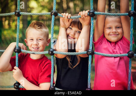 Dei bambini felici tenendo un net sul parco giochi, Debica, Polonia Foto Stock