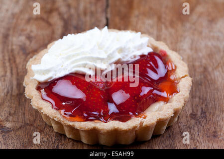 Torta di fragole con panna sul tavolo di legno Foto Stock