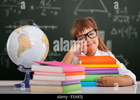 Sorridente bambina con la pila di libri, Debica, Polonia. Foto Stock