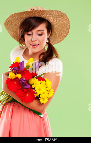 Donna che indossa cappello di paglia mantenendo la molla fiore Debica, Polonia Foto Stock