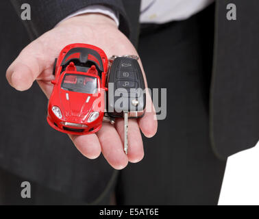 Auto rossa e la chiave nel venditore la mano vicino fino Foto Stock