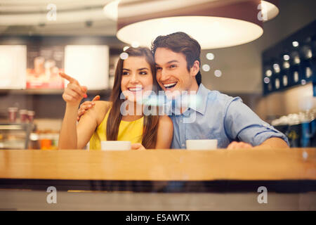 Felice coppia giovane in cafe che punta a qualcosa Debica, Polonia Foto Stock