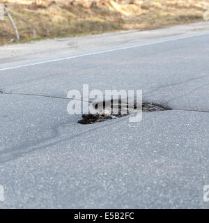 Cattiva strada, grande foro nella strada asfalto Foto Stock