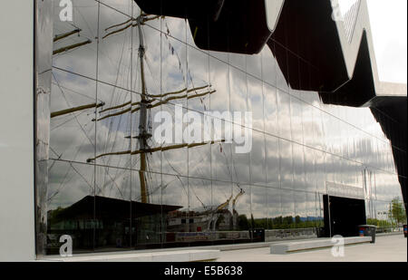 Vista del Riverside Museum di Glasgow con un riflesso della Tall Ship il Glenlee ormeggiati davanti Foto Stock