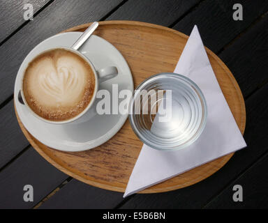 Tazza di caffè e un bicchiere di acqua al di fuori sul tavolo del bar, Inghilterra Foto Stock