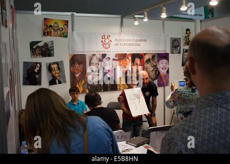 Ragazzo in posa per la foto con la sua caricatura e artista caricaturista alla Fiera Internazionale Comic di Barcellona il 17 maggio 2014 a Barcellona, Catalogna, Spagna. Foto Stock
