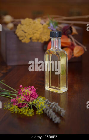 Ancora la vita della bottiglia di profumo di fiori su una superficie di legno. Foto Stock