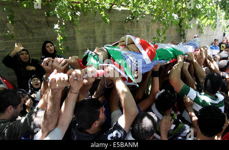 (140726) -- NABLUS, luglio 26, 2014 (Xinhua) -- palestinesi portano i corpi di Tayyeb Shehada, 21 e Mohammed Odeh, 22, di cui i medici hanno detto sono stati uccisi durante gli scontri con le truppe israeliane venerdì durante i funerali in Cisgiordania città di Hawara vicino a Nablus, 26 luglio 2014. I medici hanno detto otto palestinesi sono stati uccisi in scontri nei pressi della Cisgiordania città di Nablus e Hebron venerdì dopo le proteste contro Israele dell operazione militare nella striscia di Gaza. (Xinhua/Ayman Nobani) Foto Stock