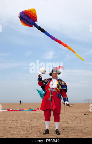 Lytham St Annes, Blackpool, 26 luglio, 2014. Town Crier, signor Colin Ballard proclamando al St. Annes kite festival. I cieli sopra di St Annes lungomare sono stati inondati di colore come favoloso display aquiloni ha preso all'aria sulla spiaggia adiacente al molo. Foto Stock