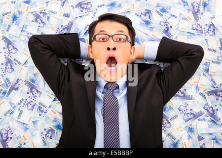 Entusiasta il business man giacente sul NUOVO DOLLARO DI TAIWAN Foto Stock