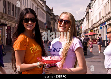 Due ragazze pubblicità e distribuzione libera Frozen Yogurt FROLICK bevande durante la torrida ondata di calore a Dundee, Regno Unito Foto Stock