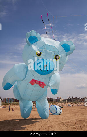 Lytham St Annes, Blackpool, 26 luglio, 2014. St. Annes kite festival. Gigantesco Orsetto aquilone gonfiabile nei cieli sopra St Annes lungomare, inondati di colore come favoloso display aquiloni ha preso all'aria sulla spiaggia adiacente al molo. I cieli sopra di St Annes lungomare sono stati inondati di colore come favoloso display aquiloni ha preso all'aria sulla spiaggia adiacente al molo, e dotato di un gigante gonfiabile blu Teddy Bear. Foto Stock