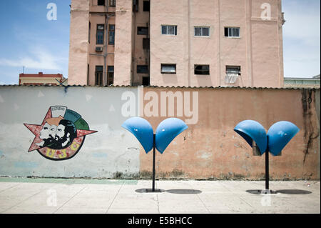 Telefono cubana nelle caselle sulla strada con una rivoluzione segno dipinto sul muro in background nel centro di Havana, Cuba Foto Stock