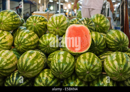 Succose fette di melone di acqua in una pila di meloni su uno stallo della frutta e della verdura souk dai pesci souk di Deira, Dubai, UAE Foto Stock