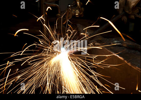 Un costruttore di metallo utilizzando una torcia a calore di un pezzo di metallo per dare forma a. Foto Stock