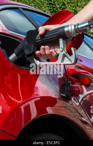 Il pompaggio del gas - riempimento di un auto il serbatoio del combustibile con gasolio o petrolio. Foto Stock