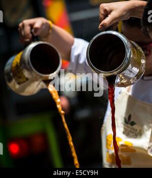 Hong Kong. 17 Giugno, 2014. Il tè di latte chef rendono stile Hong Kong tè latte di Causeway Bay nel sud della Cina di Hong Kong, 28 luglio 2014. Per celebrare questo stile Hong Kong il tè di latte è sulla lista di Hong Kong di primo patrimonio culturale immateriale inventario che è stata annunciata dai Servizi ricreativi e culturali dipartimento di Hong Kong il 17 giugno 2014, l'associazione di caffè e tè di Hong Kong ha invitato il latte chef di tè per visualizzare il latte per la preparazione di tè delle competenze a Causeway Bay lunedì. © Lui Siu Wai/Xinhua/Alamy Live News Foto Stock