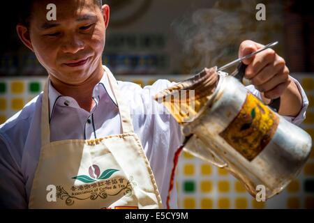 Hong Kong. 17 Giugno, 2014. Un tè di latte chef rende stile Hong Kong tè latte di Causeway Bay nel sud della Cina di Hong Kong, 28 luglio 2014. Per celebrare questo stile Hong Kong il tè di latte è sulla lista di Hong Kong di primo patrimonio culturale immateriale inventario che è stata annunciata dai Servizi ricreativi e culturali dipartimento di Hong Kong il 17 giugno 2014, l'associazione di caffè e tè di Hong Kong ha invitato il latte chef di tè per visualizzare il latte per la preparazione di tè delle competenze a Causeway Bay lunedì. © Lui Siu Wai/Xinhua/Alamy Live News Foto Stock