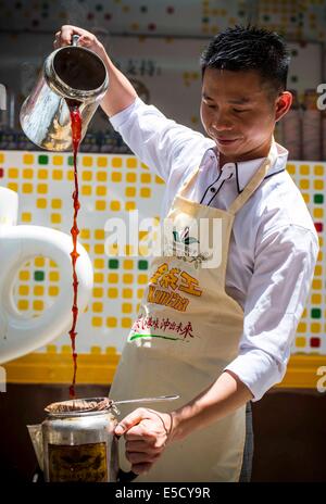 Hong Kong. 17 Giugno, 2014. Un tè di latte chef rende stile Hong Kong tè latte di Causeway Bay nel sud della Cina di Hong Kong, 28 luglio 2014. Per celebrare questo stile Hong Kong il tè di latte è sulla lista di Hong Kong di primo patrimonio culturale immateriale inventario che è stata annunciata dai Servizi ricreativi e culturali dipartimento di Hong Kong il 17 giugno 2014, l'associazione di caffè e tè di Hong Kong ha invitato il latte chef di tè per visualizzare il latte per la preparazione di tè delle competenze a Causeway Bay lunedì. © Lui Siu Wai/Xinhua/Alamy Live News Foto Stock