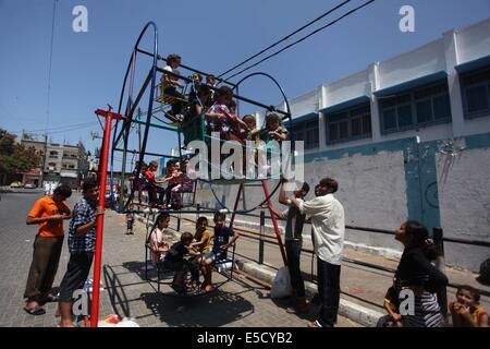 La città di Gaza, Striscia di Gaza, Territori palestinesi. 28 Luglio, 2014. Bambini palestinesi giocare su un mini ruota panoramica Ferris al di fuori di una organizzazione delle Nazioni Unite (ONU) School di Jabalia nel nord della striscia di Gaza, il 28 luglio 2014, sull'inizio della festività musulmana di Eid termina il mese di digiuno del Ramadan. Serbatoio israeliano fuoco uccise un quattro-anno-vecchio ragazzo nel nord della Striscia di Gaza, la prima morte poiché i due lati ha cominciato a osservare una tregua non ufficiale, medics palestinese detto credito: Ashraf Amra/immagini APA/ZUMA filo/Alamy Live News Foto Stock