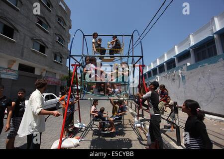 La città di Gaza, Striscia di Gaza, Territori palestinesi. 28 Luglio, 2014. Bambini palestinesi giocare su un mini ruota panoramica Ferris al di fuori di una organizzazione delle Nazioni Unite (ONU) School di Jabalia nel nord della striscia di Gaza, il 28 luglio 2014, sull'inizio della festività musulmana di Eid termina il mese di digiuno del Ramadan. Serbatoio israeliano fuoco uccise un quattro-anno-vecchio ragazzo nel nord della Striscia di Gaza, la prima morte poiché i due lati ha cominciato a osservare una tregua non ufficiale, medics palestinese detto credito: Ashraf Amra/immagini APA/ZUMA filo/Alamy Live News Foto Stock