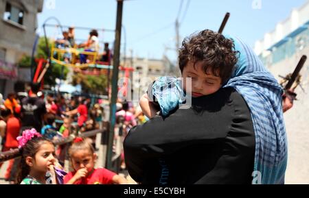 La città di Gaza, Striscia di Gaza, Territori palestinesi. 28 Luglio, 2014. Bambini palestinesi giocare su un mini ruota panoramica Ferris al di fuori di una organizzazione delle Nazioni Unite (ONU) School di Jabalia nel nord della striscia di Gaza, il 28 luglio 2014, sull'inizio della festività musulmana di Eid termina il mese di digiuno del Ramadan. Serbatoio israeliano fuoco uccise un quattro-anno-vecchio ragazzo nel nord della Striscia di Gaza, la prima morte poiché i due lati ha cominciato a osservare una tregua non ufficiale, medics palestinese detto credito: Ashraf Amra/immagini APA/ZUMA filo/Alamy Live News Foto Stock