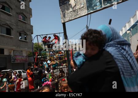 La città di Gaza, Striscia di Gaza, Territori palestinesi. 28 Luglio, 2014. Bambini palestinesi giocare su un mini ruota panoramica Ferris al di fuori di una organizzazione delle Nazioni Unite (ONU) School di Jabalia nel nord della striscia di Gaza, il 28 luglio 2014, sull'inizio della festività musulmana di Eid termina il mese di digiuno del Ramadan. Serbatoio israeliano fuoco uccise un quattro-anno-vecchio ragazzo nel nord della Striscia di Gaza, la prima morte poiché i due lati ha cominciato a osservare una tregua non ufficiale, medics palestinese detto credito: Ashraf Amra/immagini APA/ZUMA filo/Alamy Live News Foto Stock