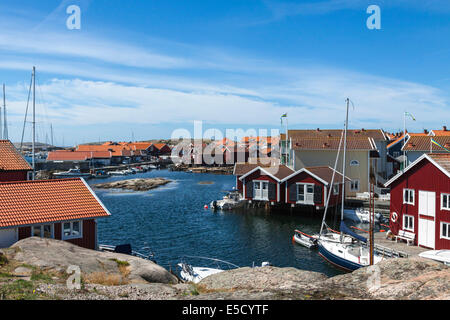 Colorate di pesca tradizionali capanne e boathouses con barche lungo il molo in legno a Smögen, Bohuslän, Svezia e Scandinavia. Foto Stock