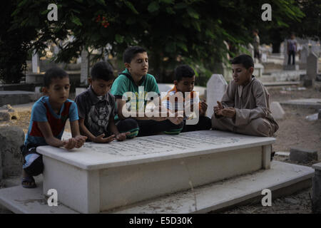 La città di Gaza. 28 Luglio, 2014. I bambini piangere sulla tomba della madre, che è stato ucciso in un attacco israeliano su Gaza il primo giorno di Eid al-Fitr in un cimitero nel centro della città di Gaza. L'U.N. Consiglio di sicurezza hanno concordato una dichiarazione domenica sollecitava Israele e Palestina ed islamisti militanti di Hamas per implementare una tregua umanitaria al di là della vacanza musulmana di Eid al-Fitr e impegnarsi in sforzi per raggiungere un cessate il fuoco duraturo. Credito: Ibrahim Khader/Pacific Press/Alamy Live News Foto Stock