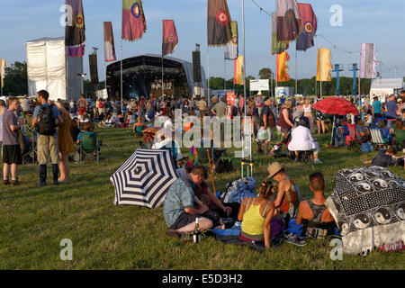 Persone rilassarsi in estate il sole, aria aperta fase, WOMAD 2014, Inghilterra, Regno Unito, GB. Foto Stock