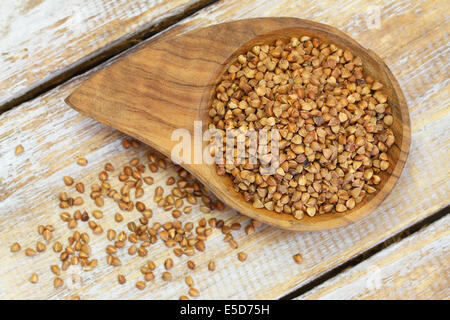 Il grano saraceno in ciotola di legno e sulla paletta di legno Foto Stock