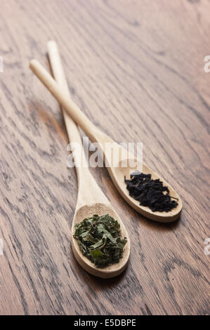 Le spezie in cucchiai di legno sul tavolo di legno Foto Stock