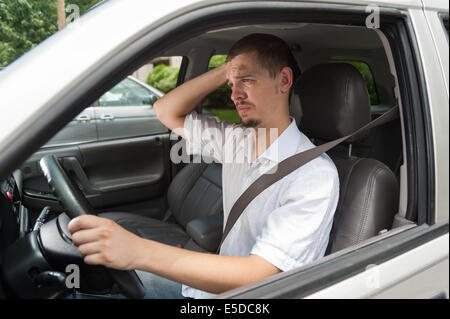 Giovani driver caucasica è a pensare a cosa fare o dove andare Foto Stock