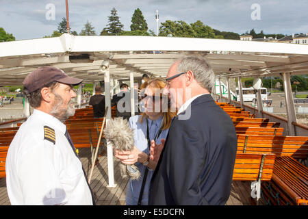 Lago di Windermere Cumbria Regno Unito 28 luglio 2014 Bowness on Windermere il sistema di cottura a vapore "MV Teal' appartenenti a Windermere crociere sul lago hosted BBC " giardinieri' ora delle interrogazioni" Lunedì 28 Luglio. Questa registrazione speciale del popolare BBC Radio 4 show ha avuto luogo nel centro del lago .Il Presidente Eric Robson era unita da partecipanti Bod Flowerdew Bunny Guinness & Pippa Greenwood rispondendo giardino le relative richieste di assistenza . Roger Bolton da "Feedback" realizzato un documentario della registrazione unica.(foto di ) Roger Bolton a parlare con il Capitano del Teal Credito: Gordon Shoosmith/Alamy Live News Foto Stock