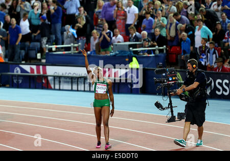 Glasgow, Scotland, Regno Unito. 28 Luglio, 2014. Benedizione Okagbare della Nigeria saluta il pubblico dopo aver vinto le donne 100m Finale al 2014 Glasgow Giochi del Commonwealth in Hampden Park a Glasgow in Scozia il 28 luglio 2014. Benedizione Okagbare ha vinto la medaglia d'oro con un tempo di 10,85 secondi. Credito: Han Yan/Xinhua/Alamy Live News Foto Stock