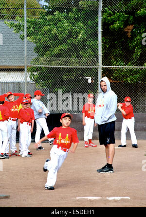 Little League coach incarica i bambini su baser unning Foto Stock