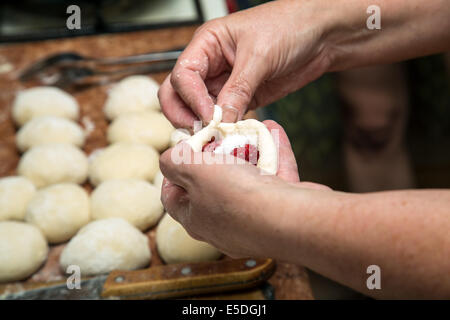 La donna le mani a fare torte con frutti di bosco Foto Stock