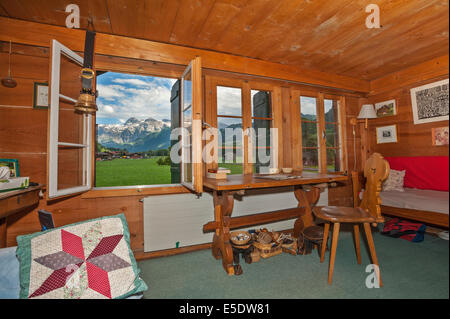 Il salotto di una tradizionale casa colonica svizzero, finestre aperte con vista sulle Alpi. Foto Stock