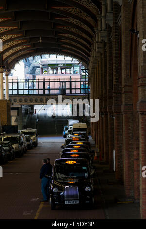 I taxi in fila fino a Liverpool Street Stazione ferroviaria a prelevare i passeggeri che arrivano alla stazione di treno. Foto Stock