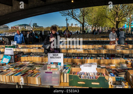Donna navigando a Southbank del mercato del libro sotto il ponte di Waterloo sulla regina a piedi Foto Stock
