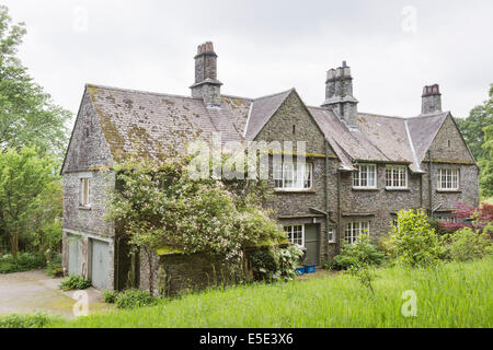 Rambling Rosa arrampicata sulla tradizionale ardesia stalattite casa al Giardino Stagshaw, Waterhead, Ambleside, Lake District, Cumbria Foto Stock